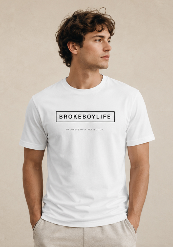 Model wearing the white BROKEBOYLIFE T-shirt with the signature logo and "Progress Over Perfection" design.