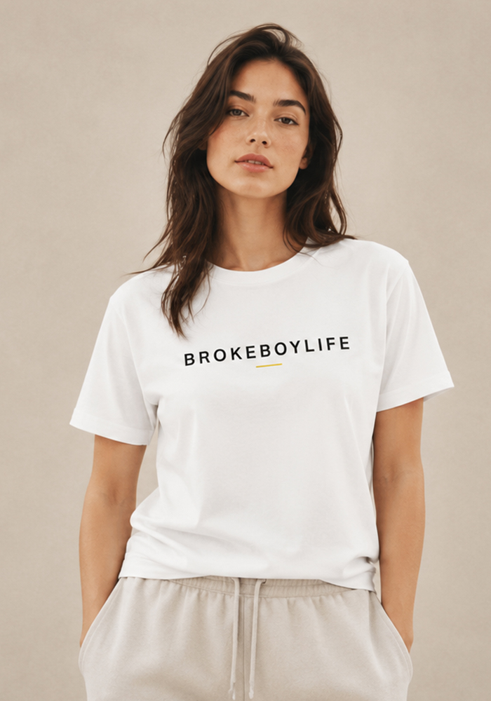 Woman wearing the white BROKEBOYLIFE logo T-shirt with minimalist black typography and gold accent detail.