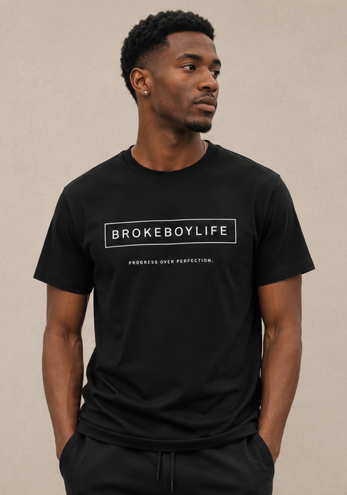 Model wearing the black BROKEBOYLIFE graphic T-shirt featuring the signature logo and "Progress Over Perfection" slogan.
